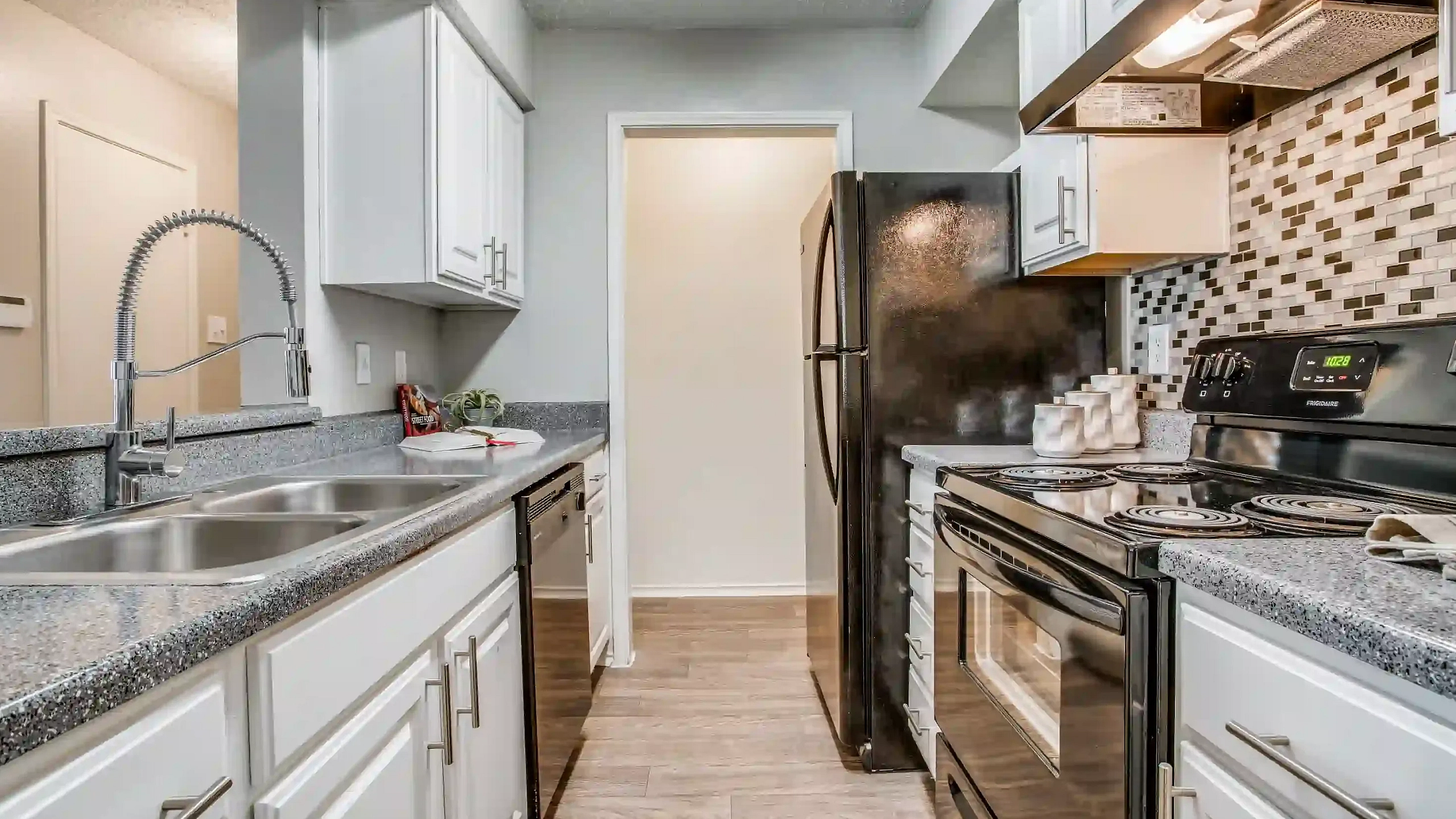 Modern kitchen featuring sleek granite countertops, stainless steel sink, and elegant tile backsplash.