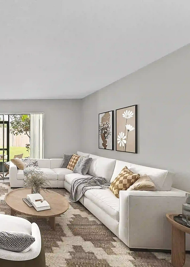 Spacious apartment living room featuring a white sectional sofa, modern furnishings, wood-look flooring, and sliding glass doors leading to a screened-in patio.