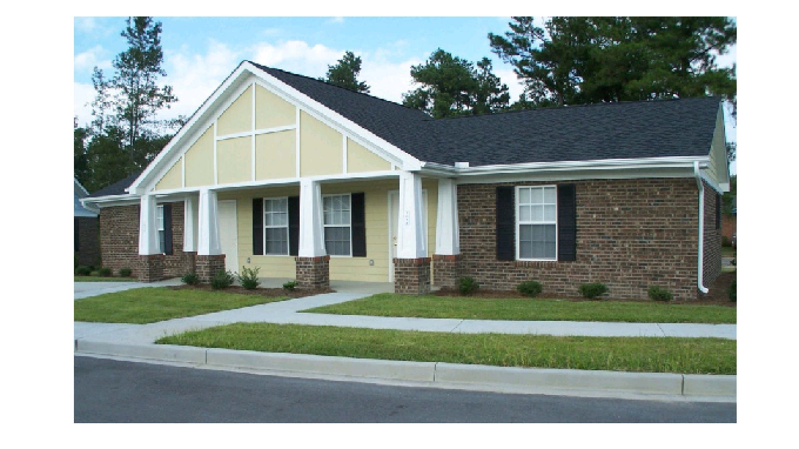 Charming single-story home featuring a welcoming exterior with brick and siding, elegant white columns, and a beautifully landscaped front yard.