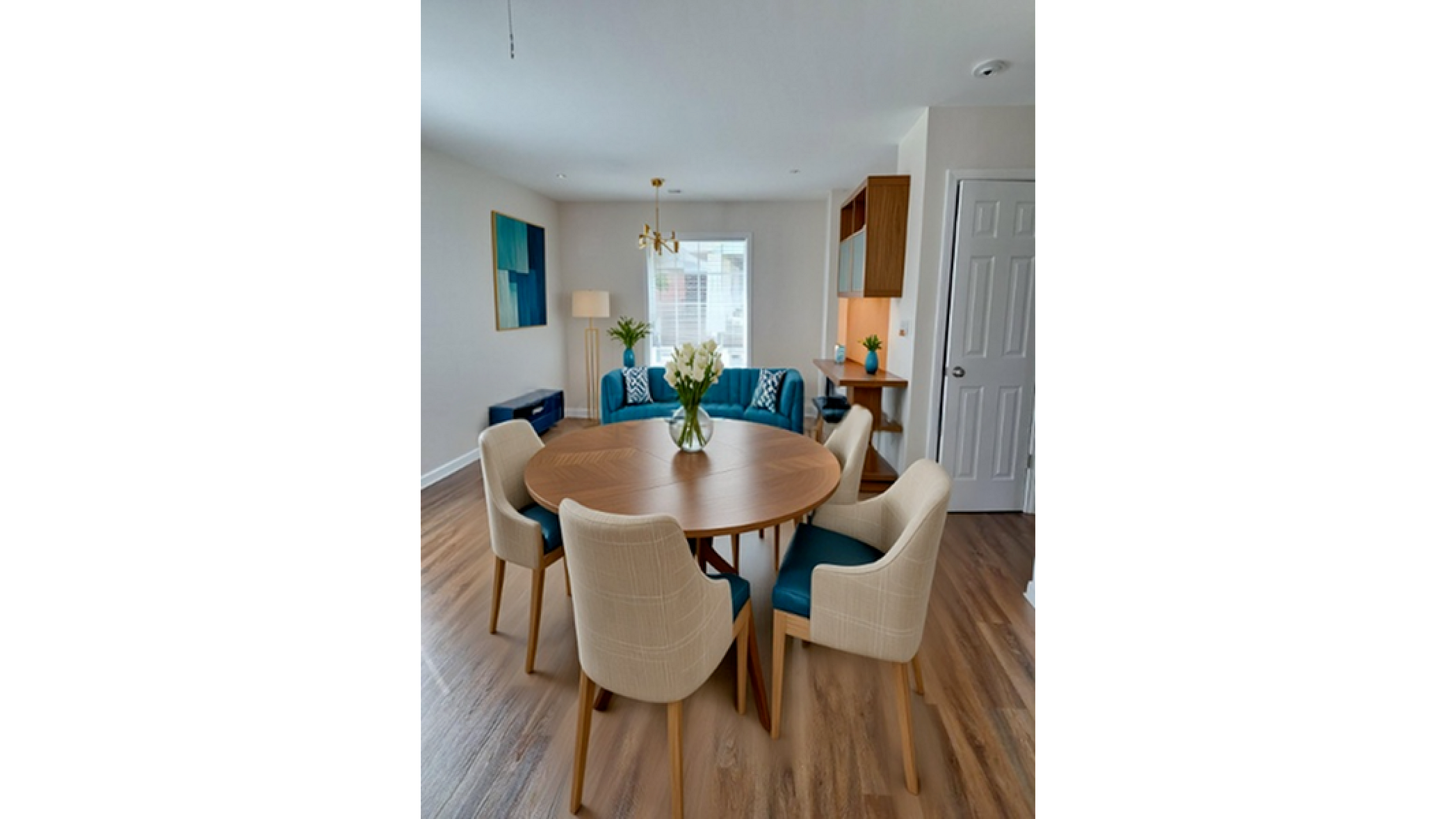 Bright and inviting dining area with a round wooden table, modern chairs, and stylish decor in a spacious living room.