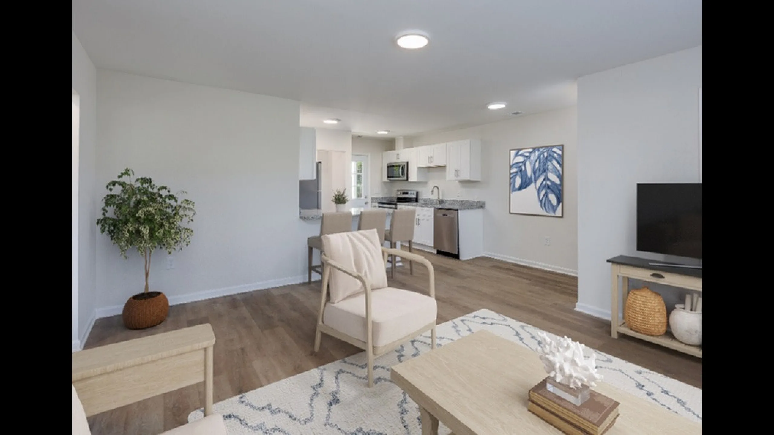Modern open-concept living area boasting elegant hardwood floors, stylish furnishings, and a sleek kitchen with stainless steel appliances.