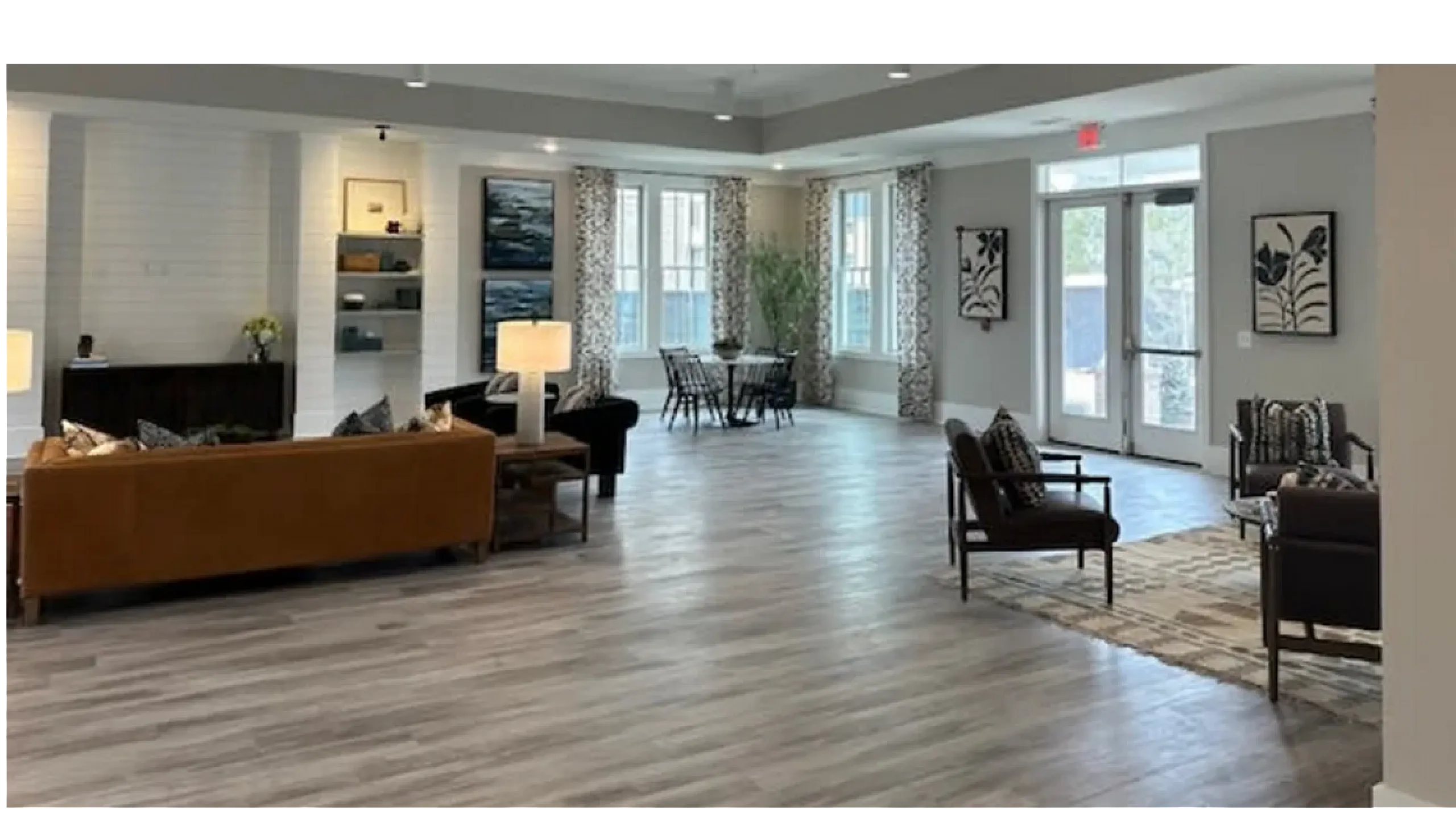 Elegant open-plan living space with modern furnishings, abundant natural light, and sleek wooden flooring, featuring a cozy seating area and dining nook.