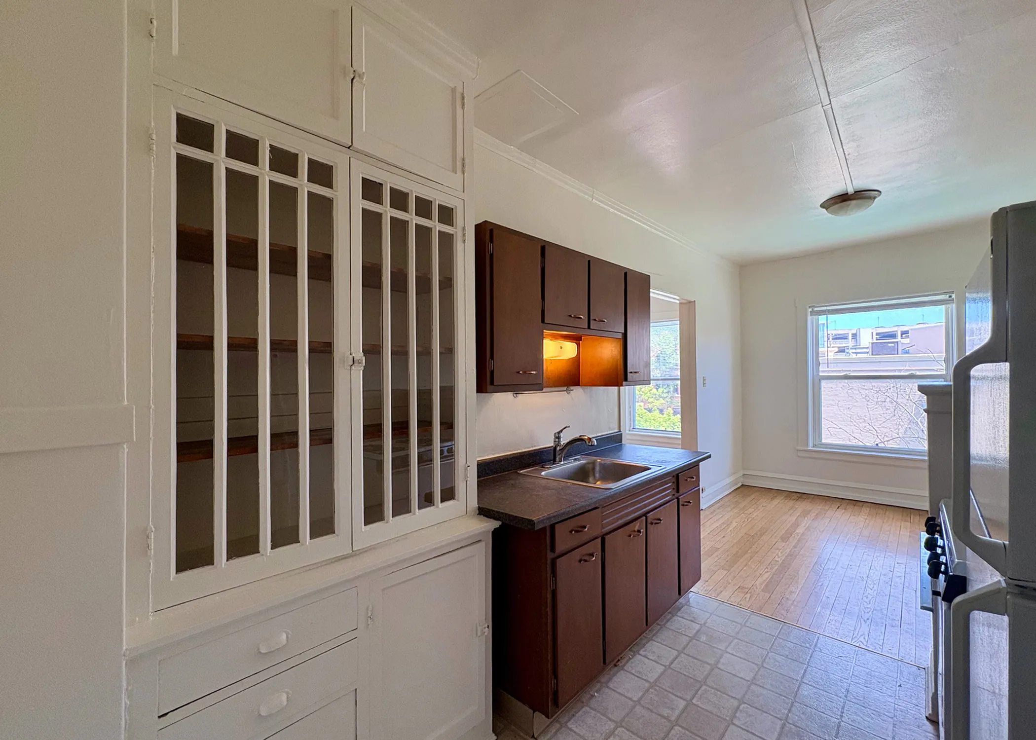 Charming kitchen with vintage cabinetry, inviting natural light, and elegant wooden floors.