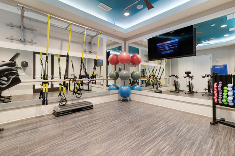 Modern fitness studio equipped with resistance bands, exercise balls, and stationary bikes, perfect for a dynamic workout experience.