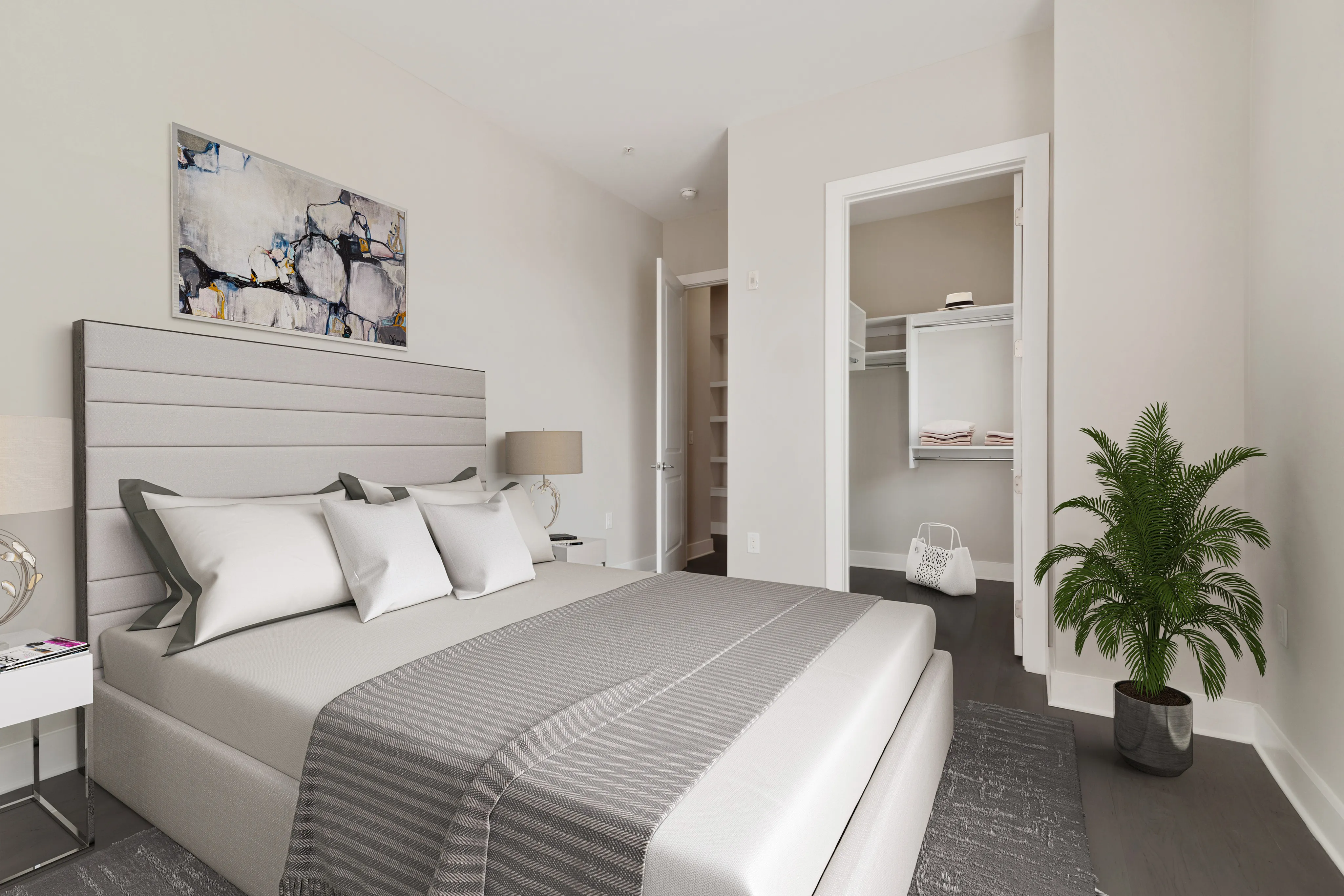 Elegant bedroom showcasing a modern bed with plush pillows, stylish artwork, and a spacious walk-in closet.