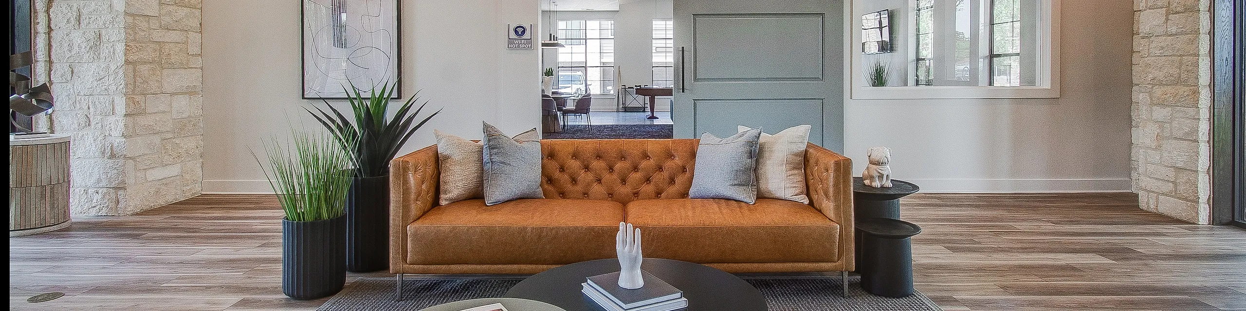 Chic and modern living room with a stylish leather sofa, sleek coffee tables, and elegant lighting, offering a warm, inviting space perfect for relaxation and social gatherings.