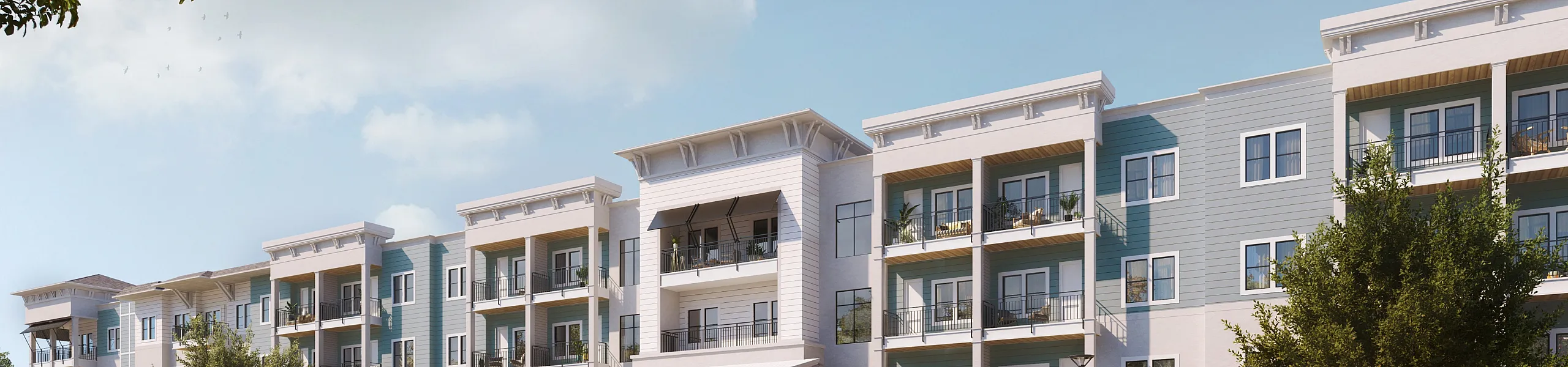 Elegant modern apartment building with spacious balconies and lush landscaping under a clear blue sky.