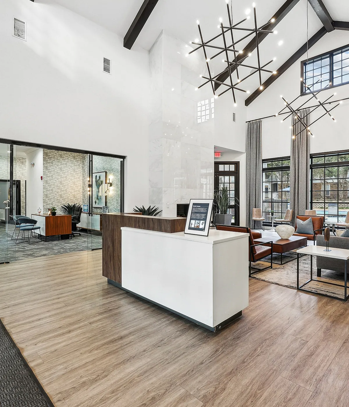 Elegant apartment lobby with high ceilings, modern chandeliers, and stylish seating area, showcasing sophistication and welcoming ambiance.