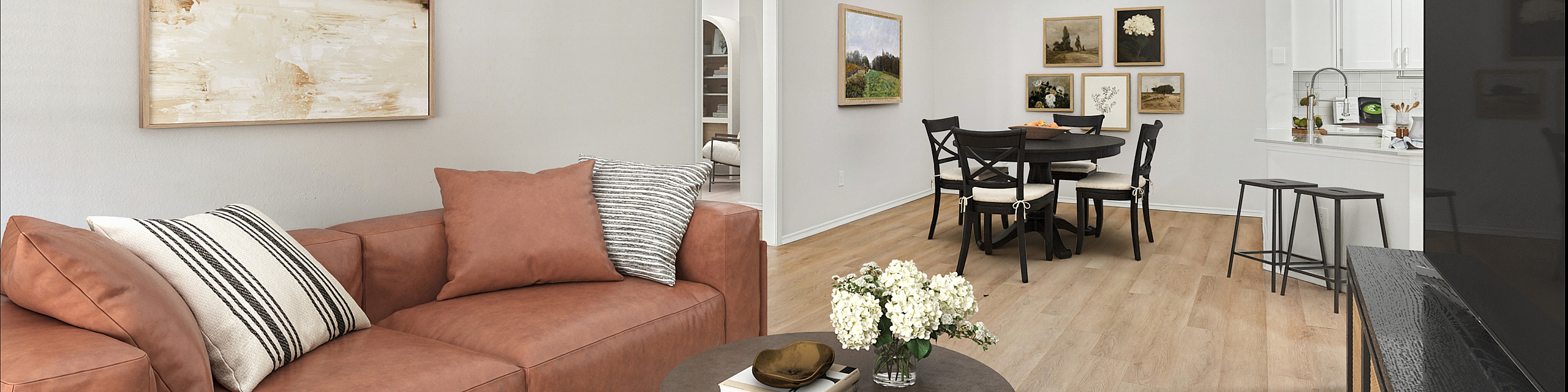 Elegant living and dining area with stylish decor, featuring a cozy leather sofa and a modern wooden dining table.