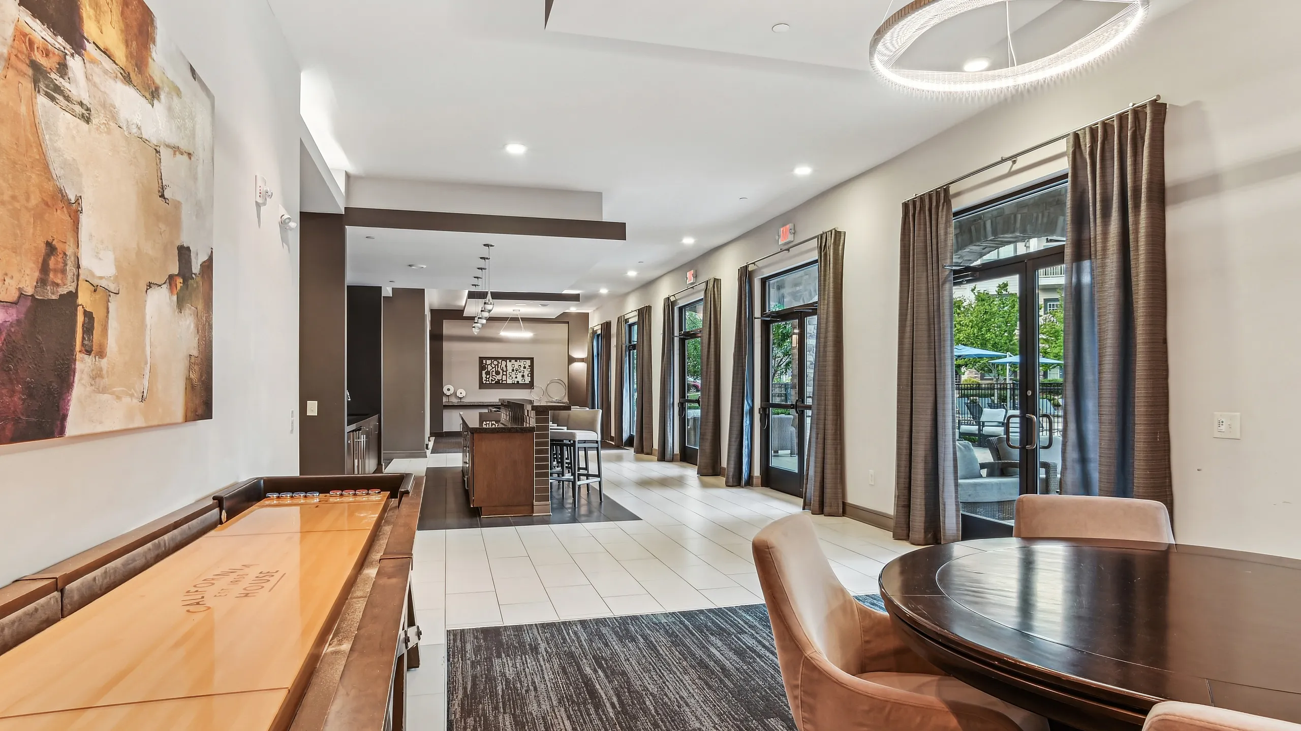Luxurious apartment interior featuring an elegant dining area, contemporary art, and natural light from large windows.