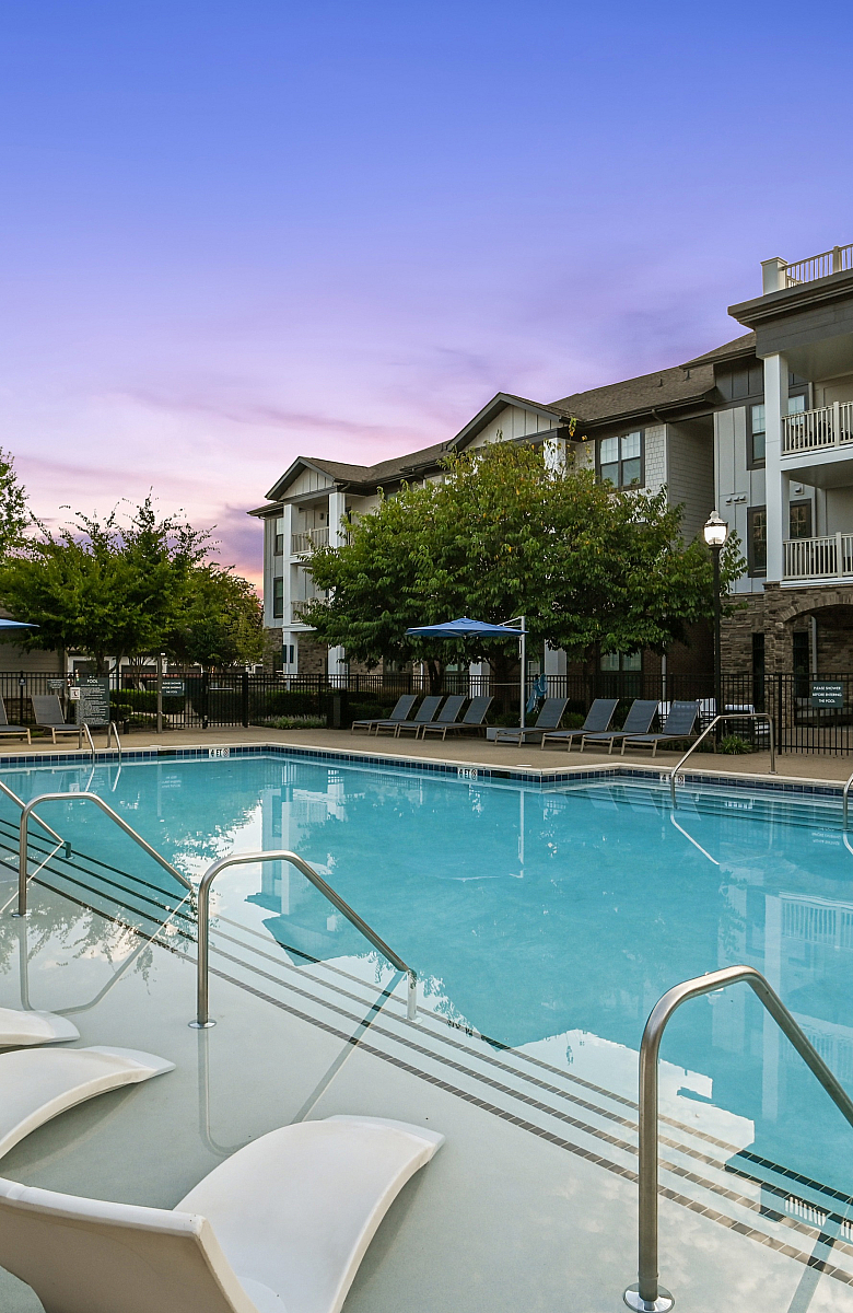 Stunning apartment complex with a luxurious swimming pool, surrounded by modern architecture and lush greenery, perfect for relaxation and leisure.