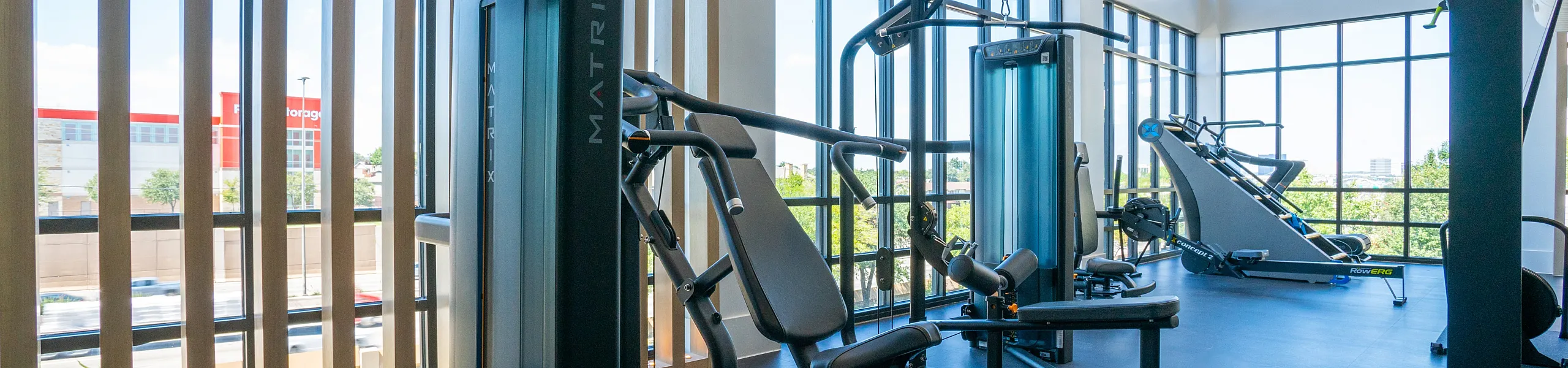 Modern fitness center with state-of-the-art equipment, featuring floor-to-ceiling windows for a bright and inspiring workout environment.