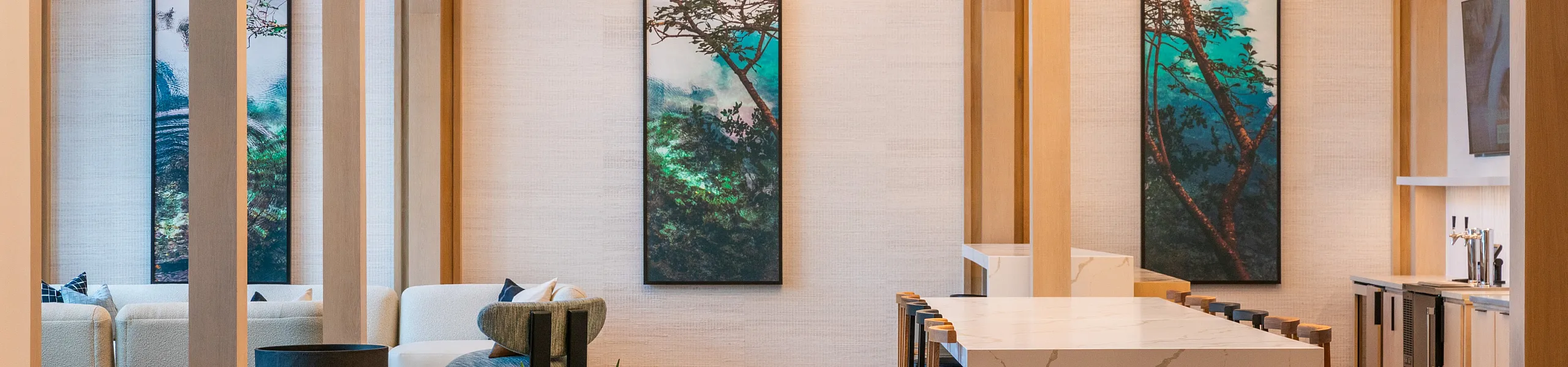 Luxurious open-concept living space with modern lighting, elegant artwork, and a sleek marble island in an upscale apartment.