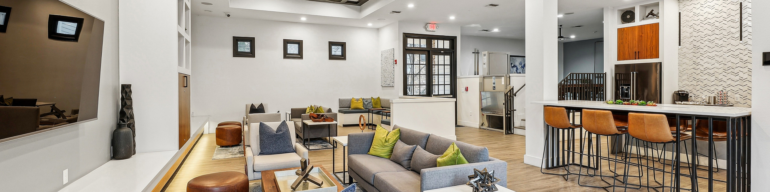 Modern, open-concept living area with stylish furnishings, elegant lighting, and a sleek bar with high stools, perfect for entertaining and relaxation.
