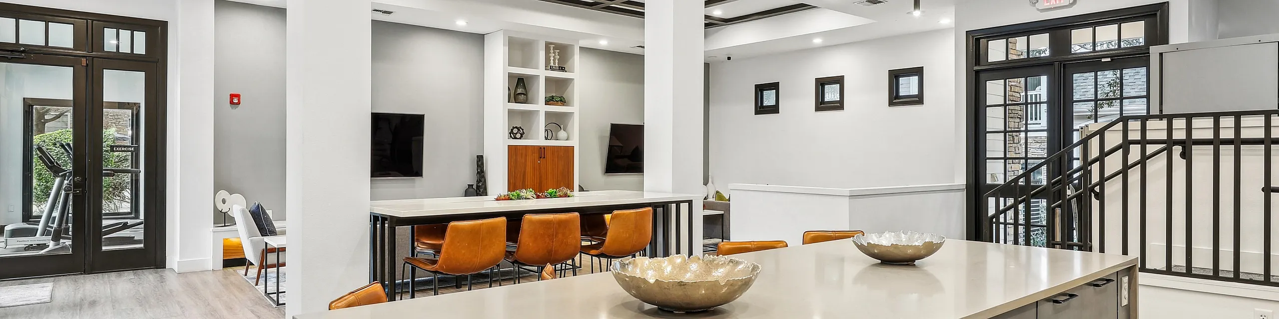 Modern communal area showcasing elegant design with a spacious kitchen island, stylish seating, and ample natural light.