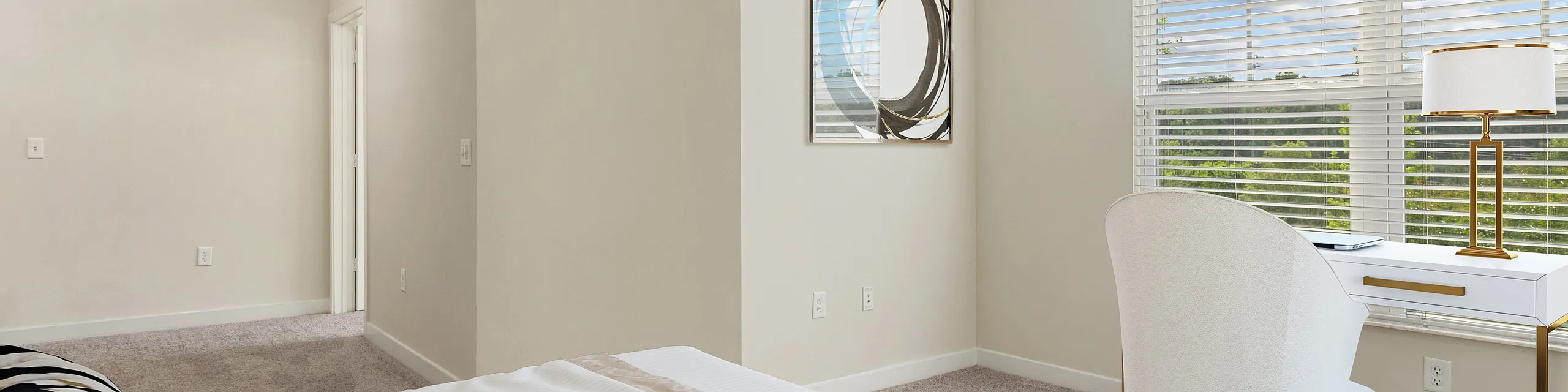 Elegant bedroom with stylish decor, large window offering natural light, and a chic workspace for productivity.