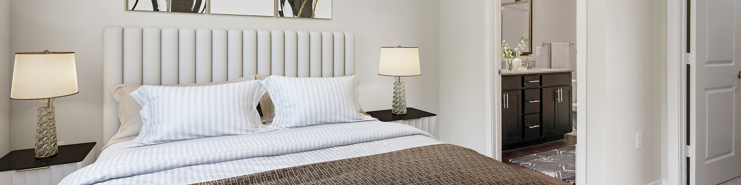 Inviting bedroom with modern decor, featuring a plush bed, elegant bedside lamps, and an ensuite bathroom.