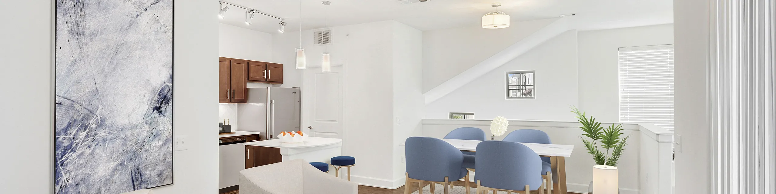 Modern open-concept living space featuring stylish seating, contemporary artwork, and a sleek kitchen with elegant dining area.