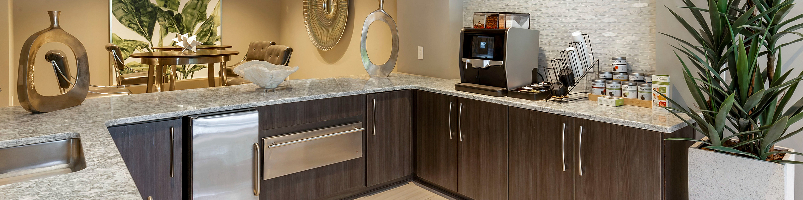 Modern kitchen featuring sleek granite countertops, elegant dark wood cabinets, and a cozy dining nook with stylish decor.