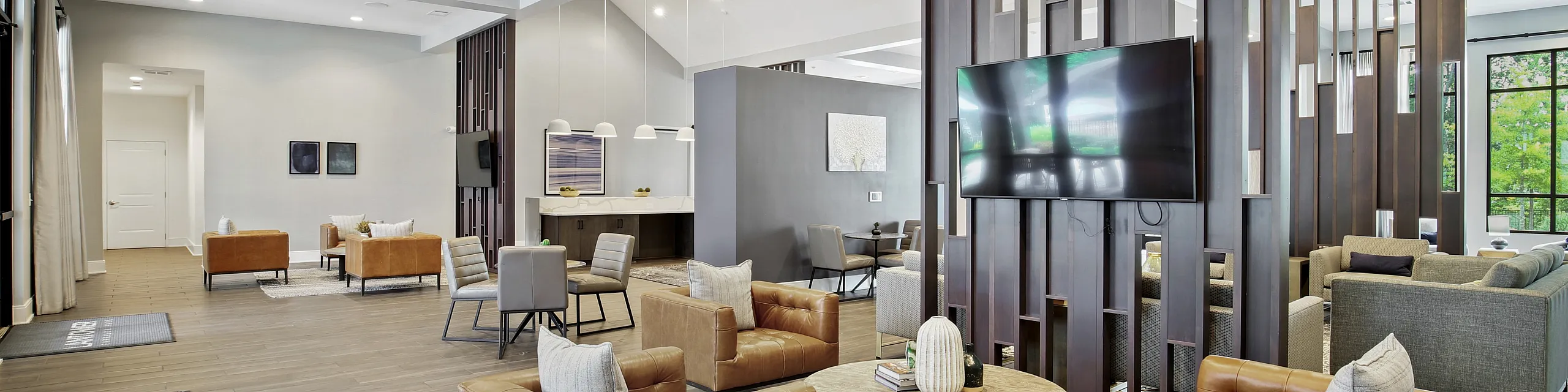 Luxurious open-concept communal space with modern seating, stylish decor, and ample natural light, featuring a flat-screen TV and a cozy seating area.