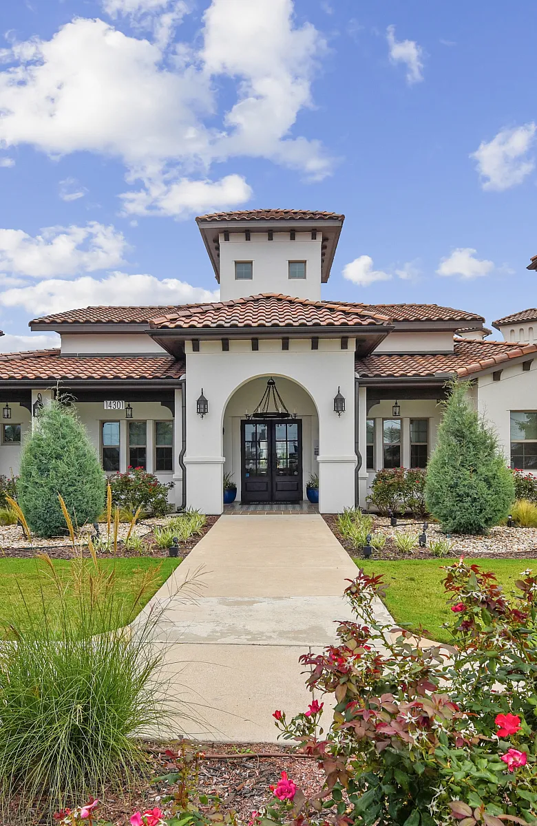 Elegant villa-style apartment building with classic red-tiled roof and manicured gardens, perfect for comfortable and stylish living.