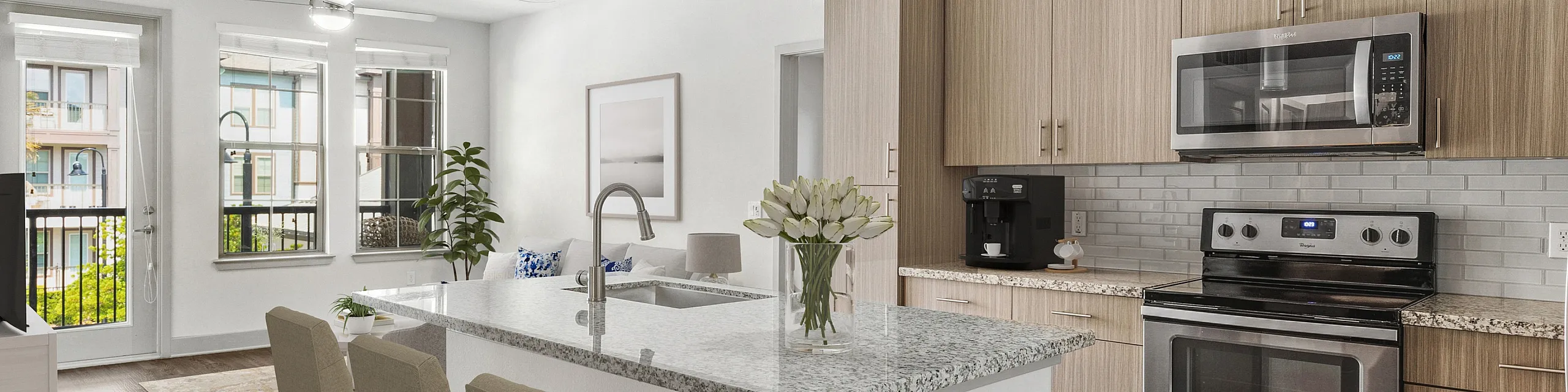 Elegant open-plan kitchen and living area with a modern island, stainless steel appliances, and bright natural lighting.