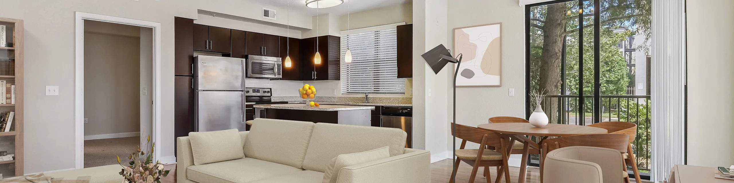 Bright living room with modern open kitchen, elegant dining area, and spacious balcony view. Highlighting stylish furniture and warm, wooden flooring.