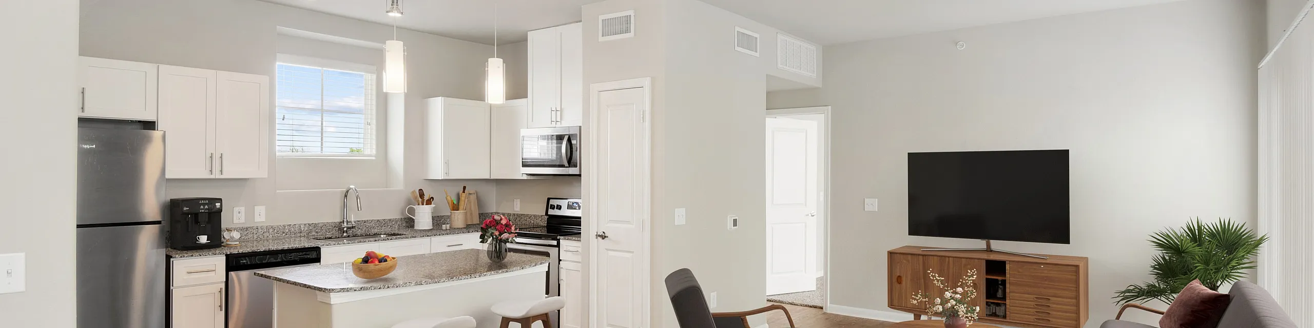 Modern open-concept living and kitchen area with sleek finishes, stainless steel appliances, and cozy seating, perfect for entertaining.