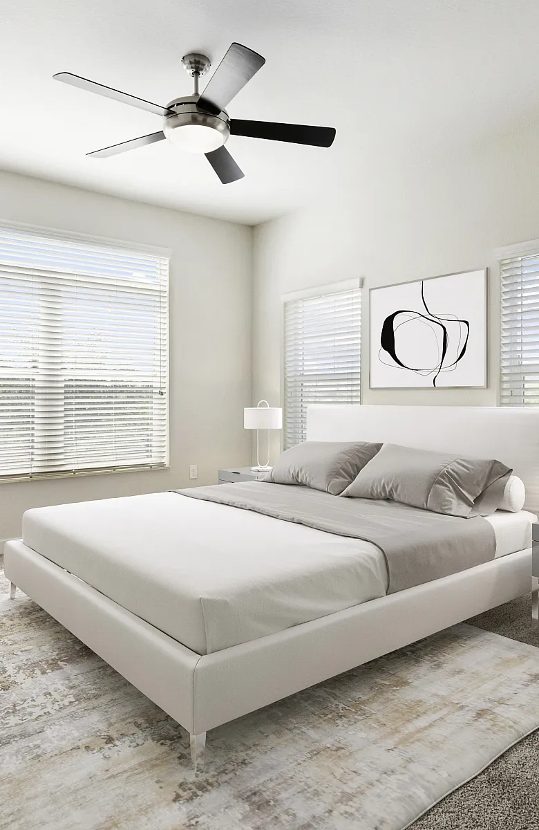 Bright and airy bedroom with modern decor, featuring a sleek white bed, stylish desk with a laptop, and a large window flooding the room with natural light.
