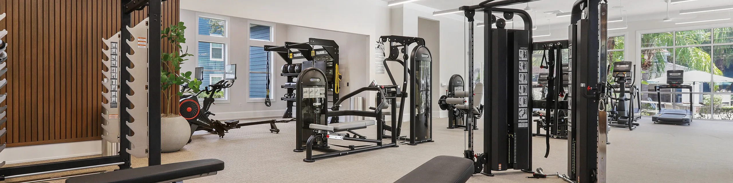 Elegant fitness center featuring state-of-the-art equipment, natural lighting, and spacious workout areas.
