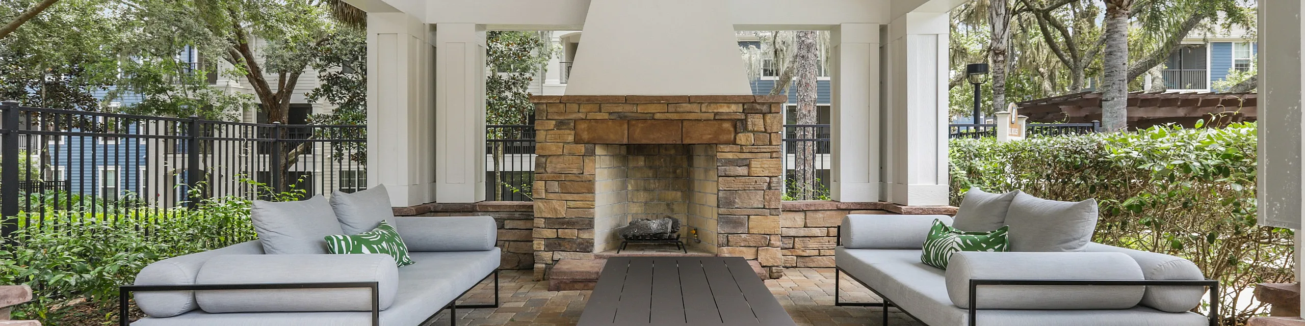 Charming outdoor patio with cozy seating, stone fireplace, and natural wood accents, perfect for relaxation and entertaining.