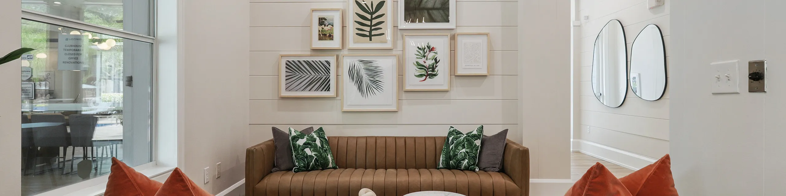Chic and inviting living area with stylish seating, vibrant pillows, and a modern gallery wall for a cozy atmosphere.