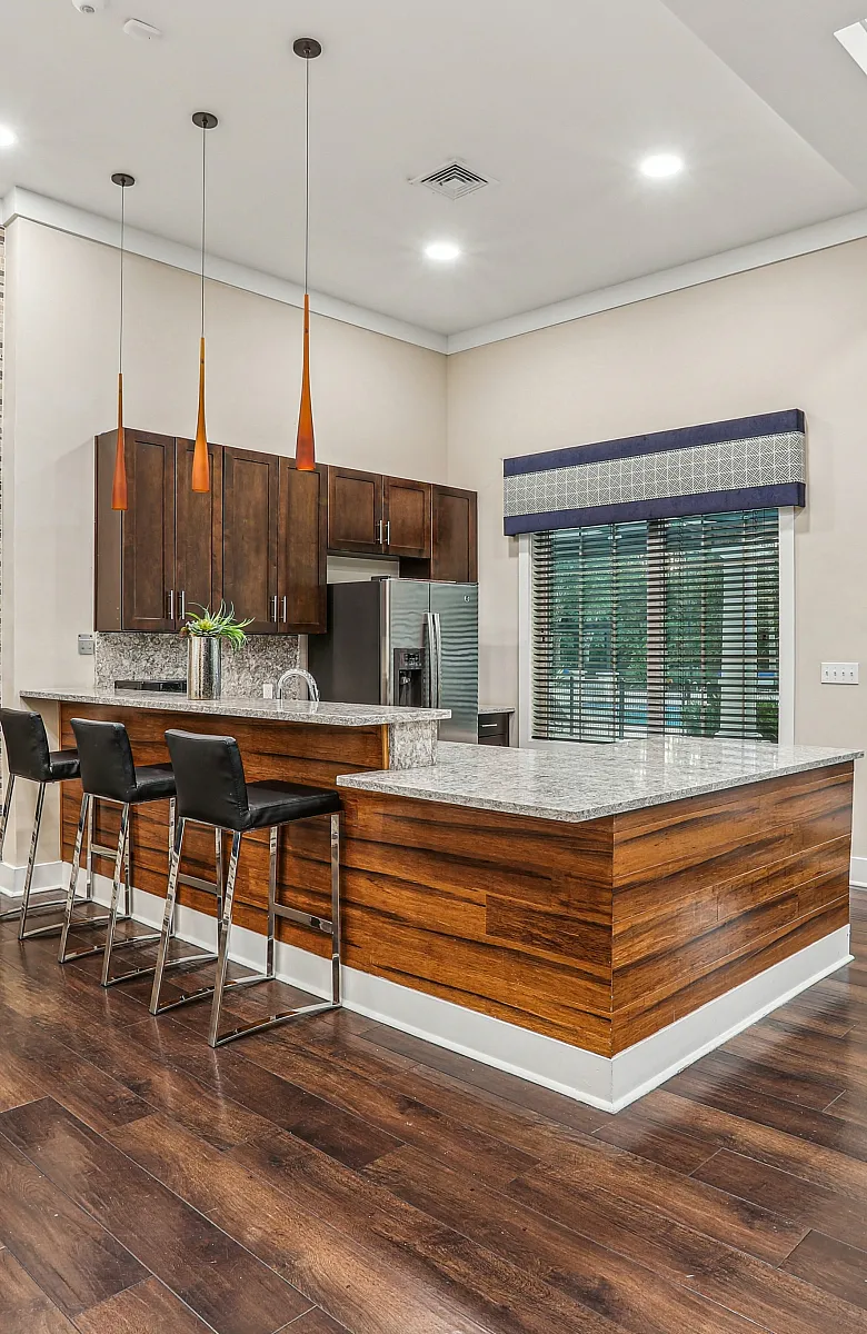 Elegant modern kitchen with stylish wood finishes, sleek granite countertops, and ambient lighting, perfect for entertaining.