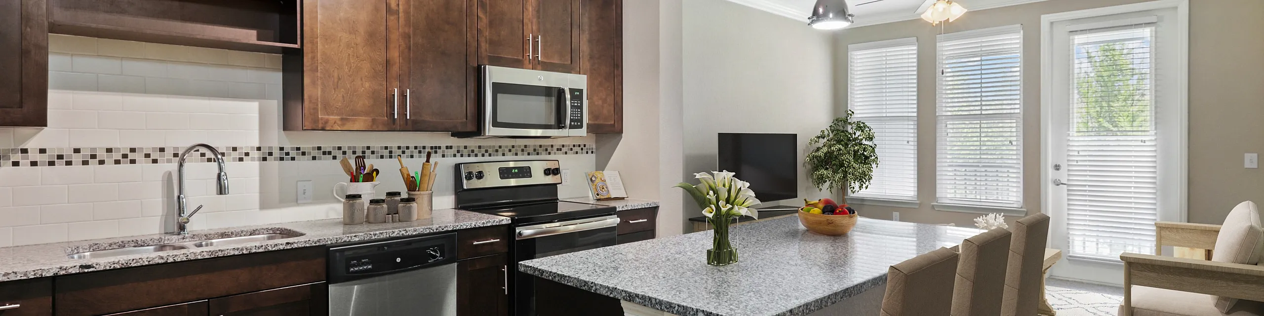 Chic modern kitchen with dark wood cabinets, granite countertops, and a cozy breakfast bar in an open-plan living area.