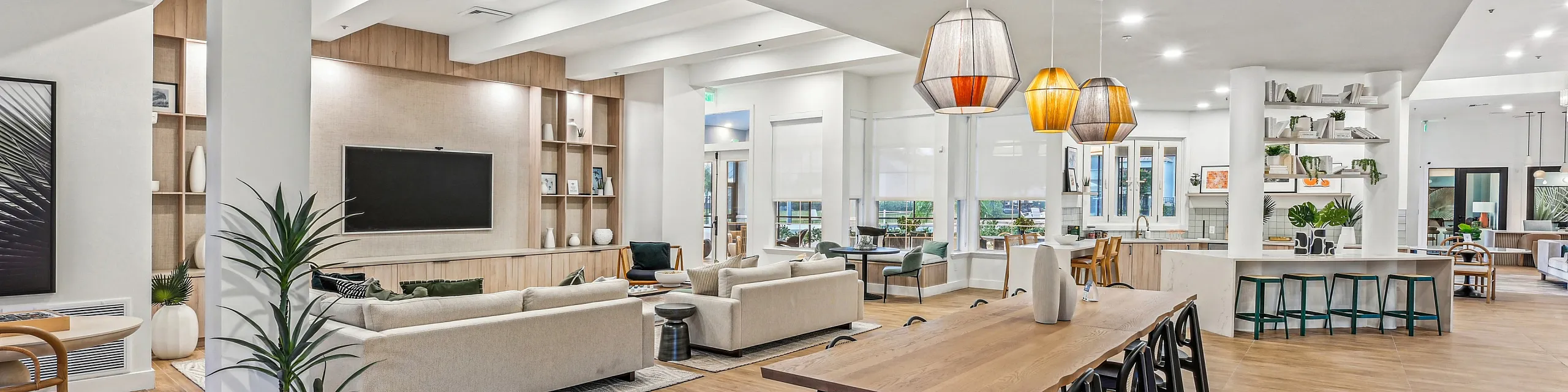 Elegant and spacious open-concept living area with modern furnishings, stylish pendant lighting, and natural wood flooring.
