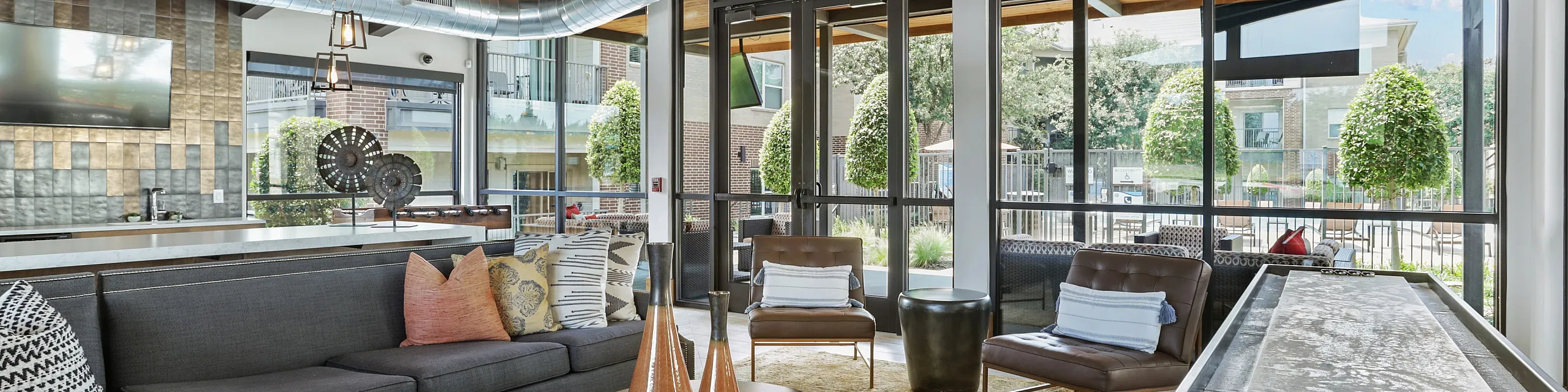 Modern and inviting living space with stylish decor, featuring a cozy sectional sofa, accent chairs, and large windows offering abundant natural light.