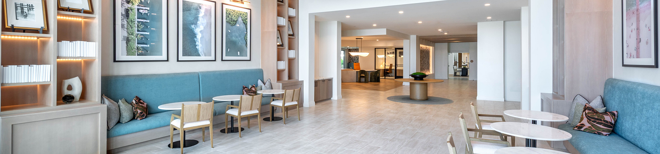 Modern apartment lobby with elegant seating, stylish lighting fixtures, and artistic decor creating a welcoming atmosphere.