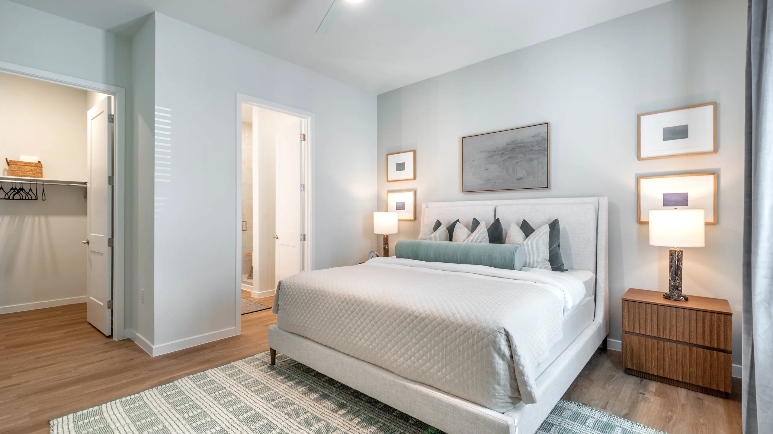 Elegant bedroom with modern decor featuring a plush bed, stylish side tables, large windows for natural light, and chic plants enhancing the soothing ambiance.