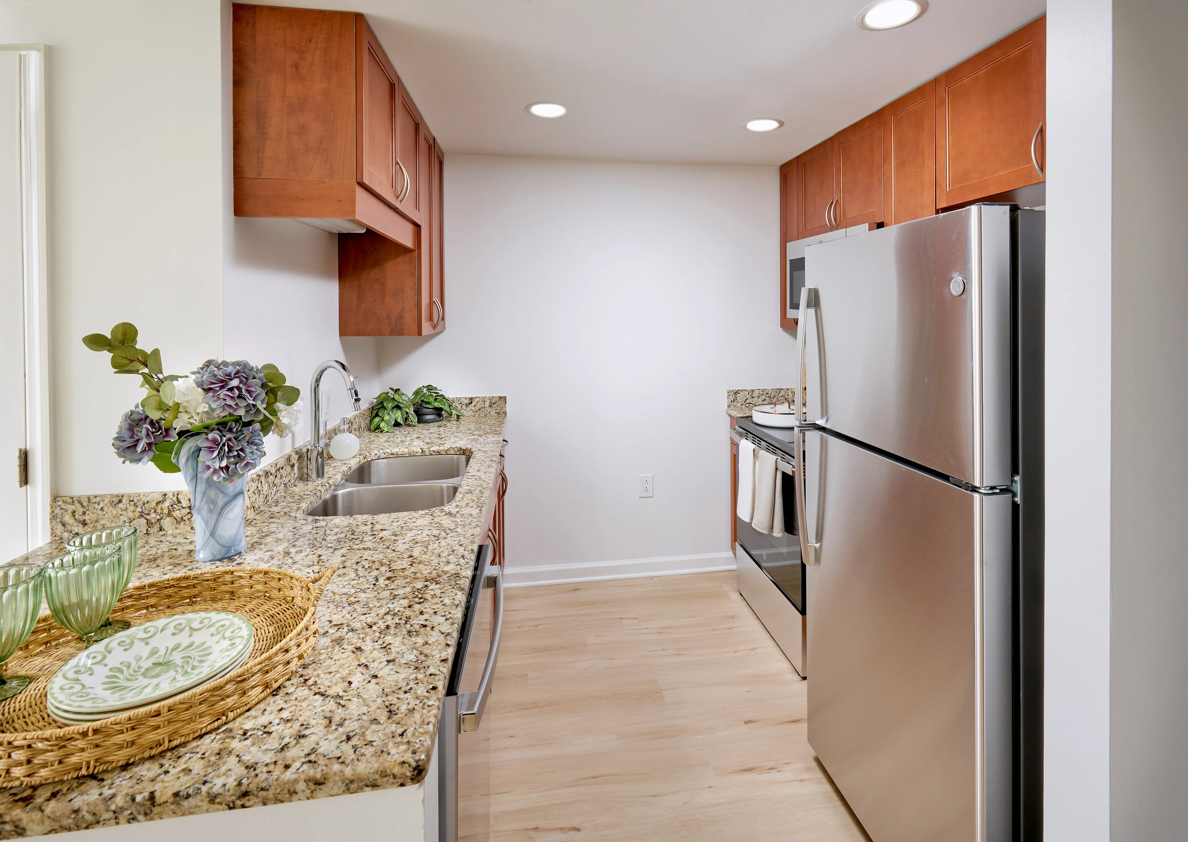 Renovated Schubert Studio kitchen with granite countertops, custom wood cabinets, stainless steel appliances, and new wood-style vinyl flooring | Meridian at Grosvenor Station | Luxury North Bethesda MD Apartments | Luxury Rockville MD Apartments