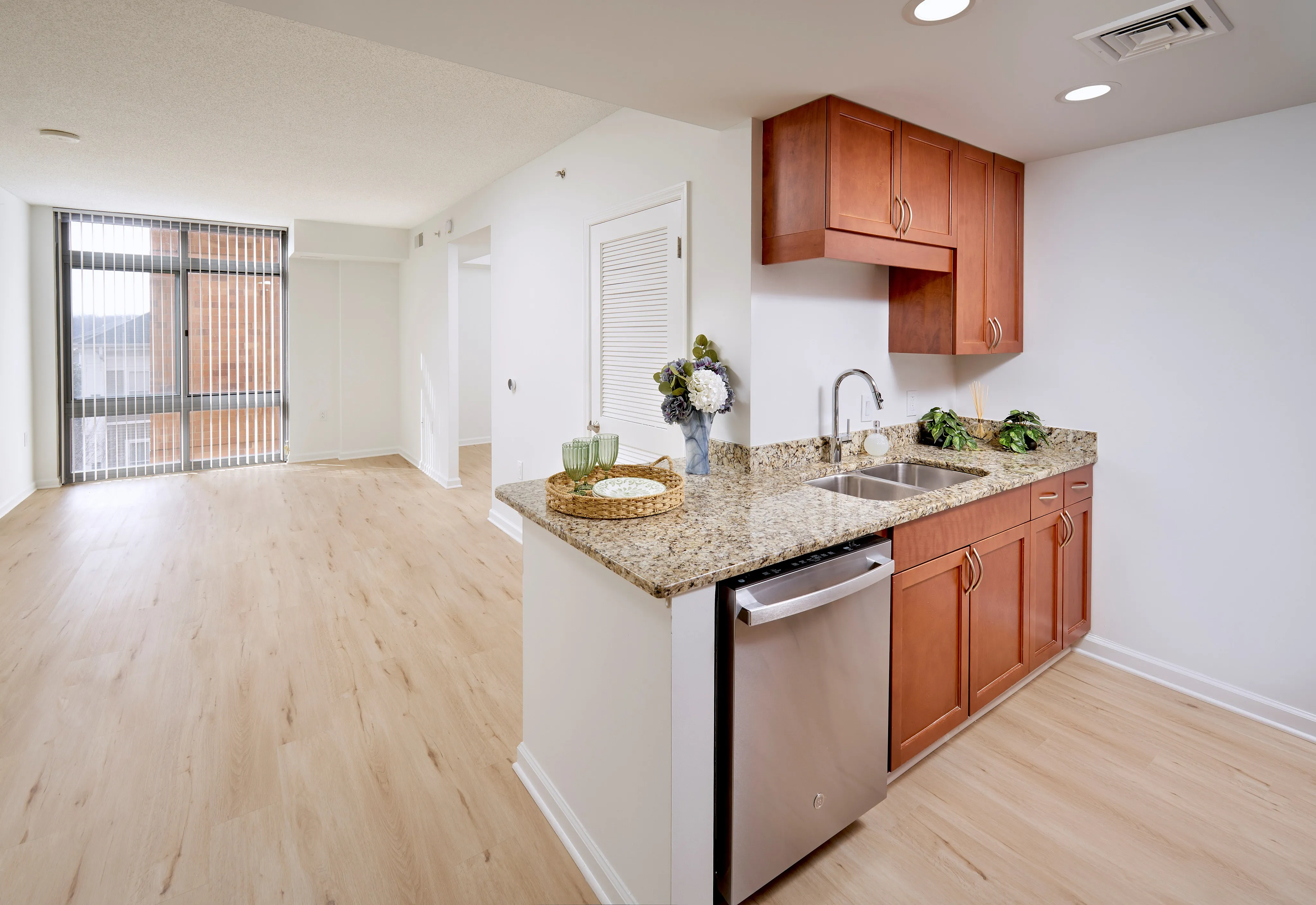 View of the Schubert Studio living room and entry to the sleeping area featuring new wood-style flooring and updated lighting | Meridian at Grosvenor Station | Luxury North Bethesda MD Apartments | Luxury Rockville MD Apartments