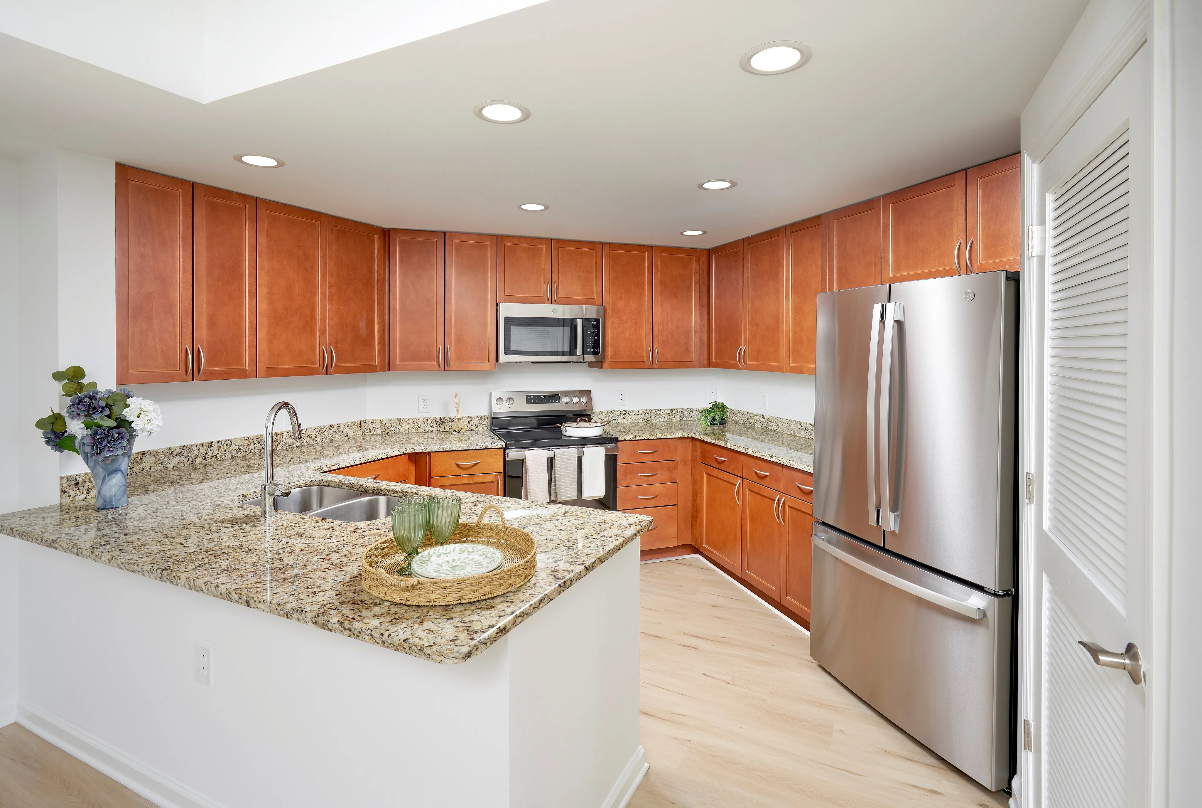 Fitzgerald One Bedroom With Den renovated kitchen showing stainless steel appliances and new wood-style flooring | Meridian at Grosvenor Station | Luxury North Bethesda MD Apartments | Luxury Rockville MD Apartments