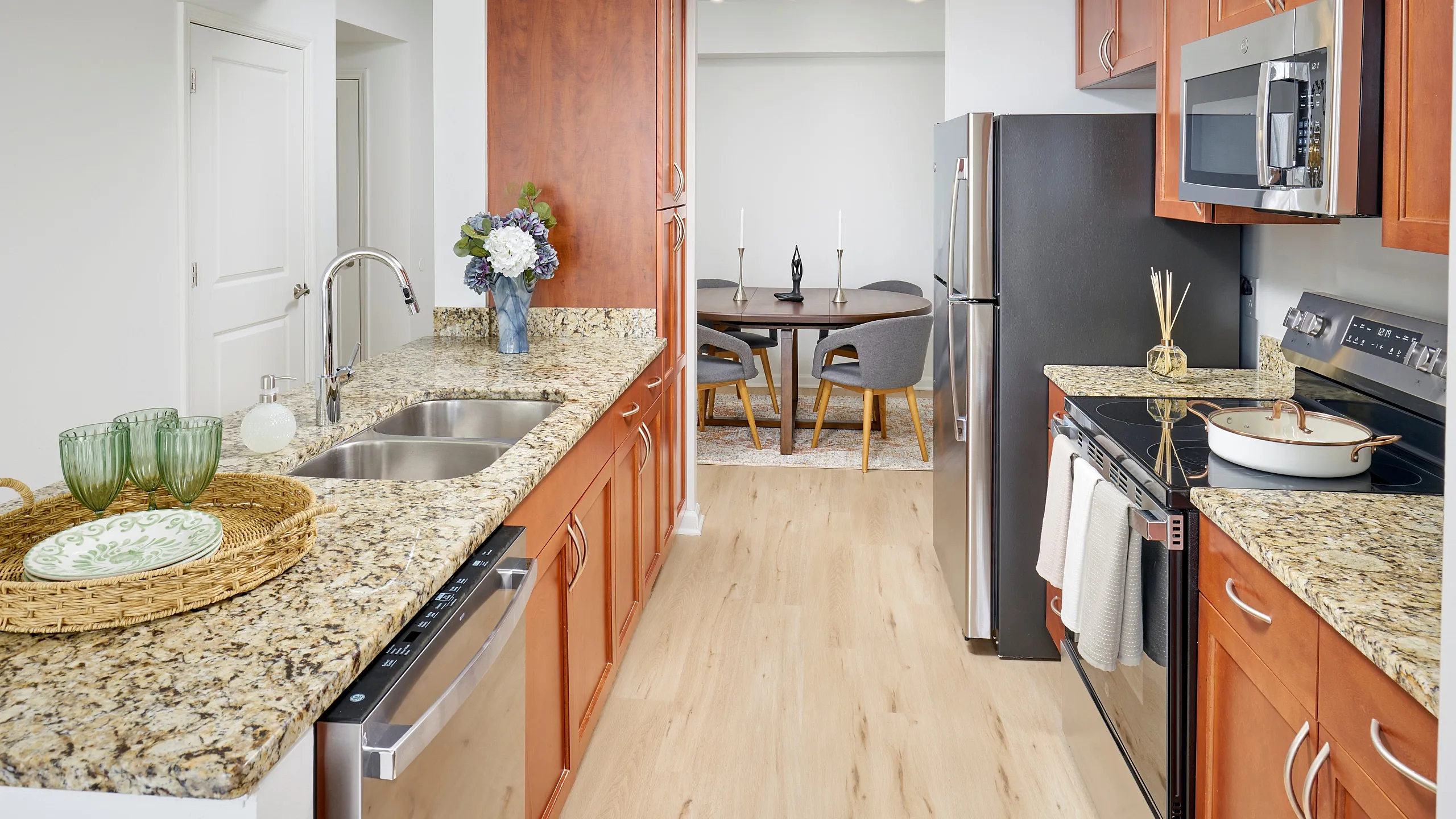 Renovated Kitchen With Granite Countertops Custom Cabinetry Stainless Steel Appliances Wood-Style Flooring & Dining Nook | Meridian at Grosvenor Station | Luxury North Bethesda Apartments | Rockville MD Apartments