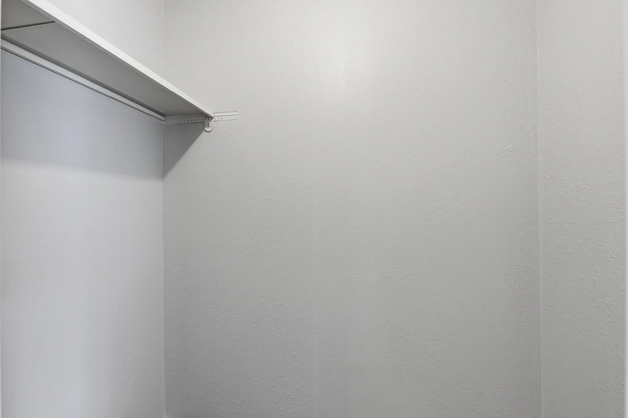 Spacious and bright walk-in closet with sleek shelving, perfect for organization and storage.