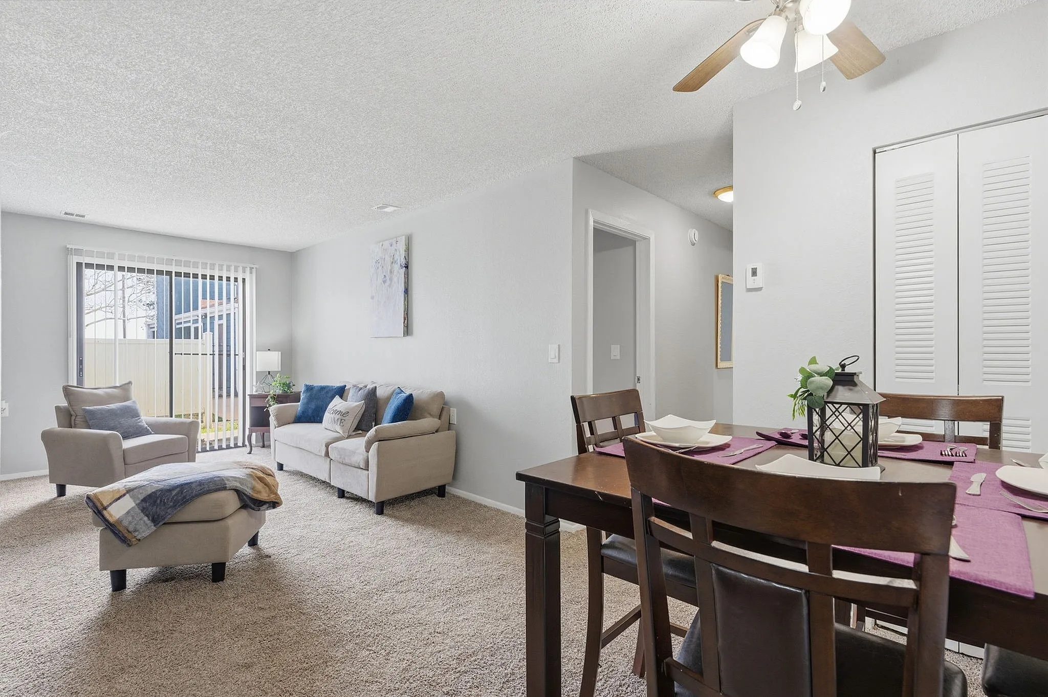 Bright and welcoming living room with plush seating, modern dining area, and large windows offering garden views.