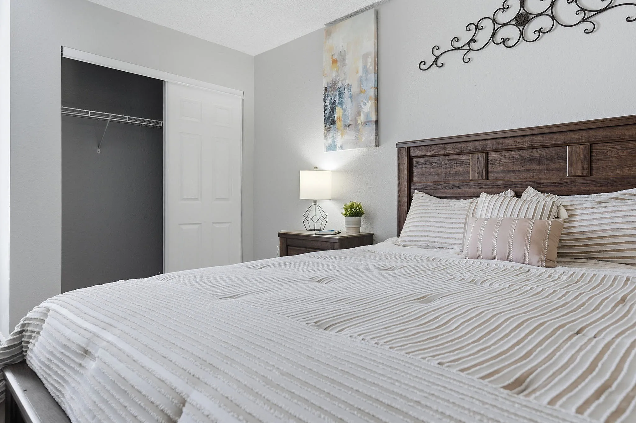Elegant bedroom interior with a plush bed, stylish wood headboard, and modern decor in neutral tones.