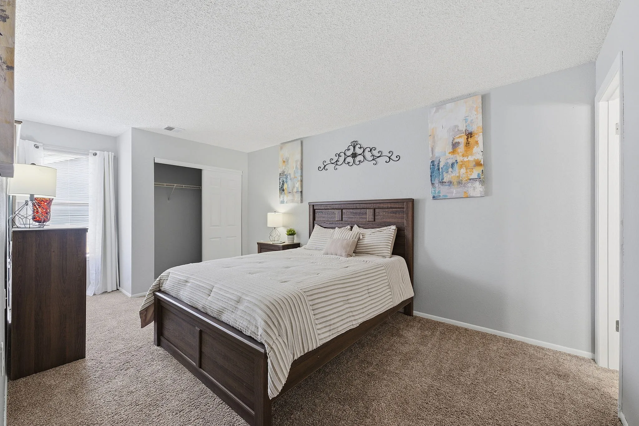 Cozy bedroom with modern decor, featuring a plush carpet, elegant wooden bed, and warm natural lighting.