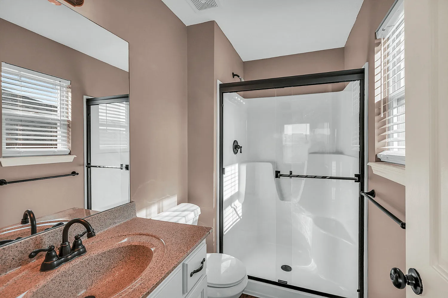 Elegant bathroom featuring a modern shower with sleek glass door, stylish vanity, and soothing natural light.