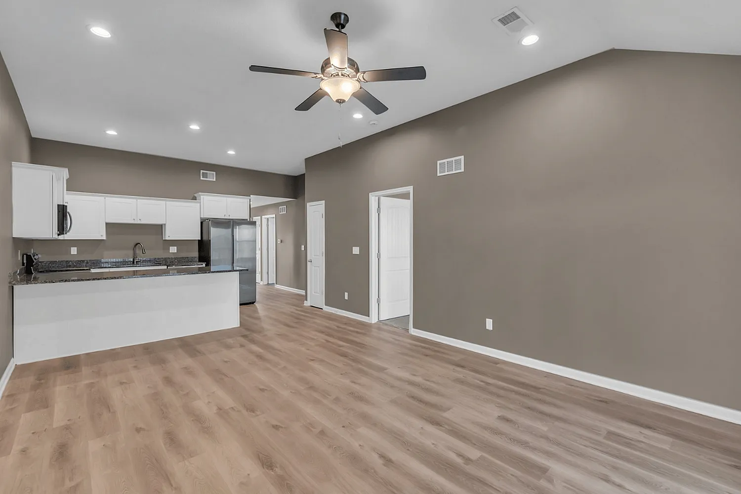 Modern open-plan kitchen with elegant countertops, stainless steel appliances, and stylish lighting, ideal for contemporary living.