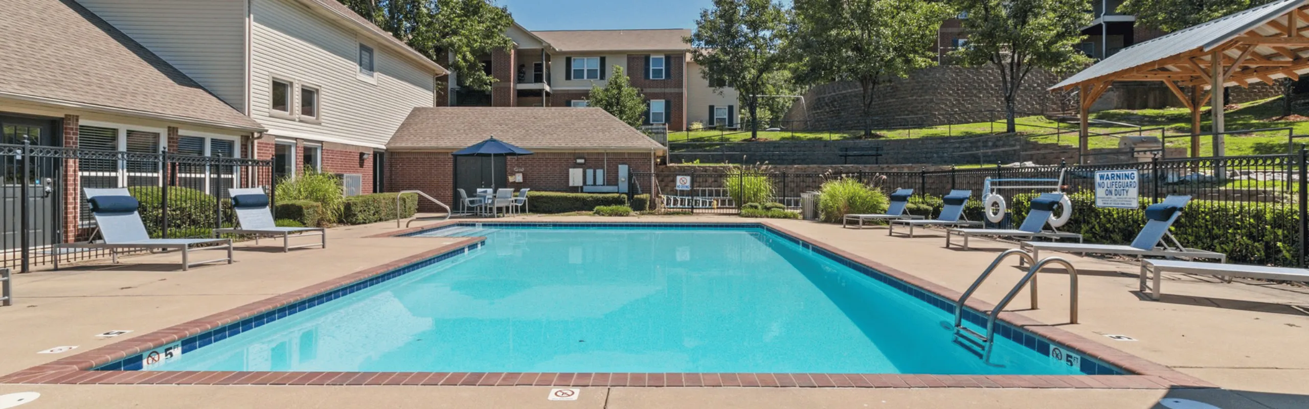 Pool with lounge chairs and clubhouse exterior