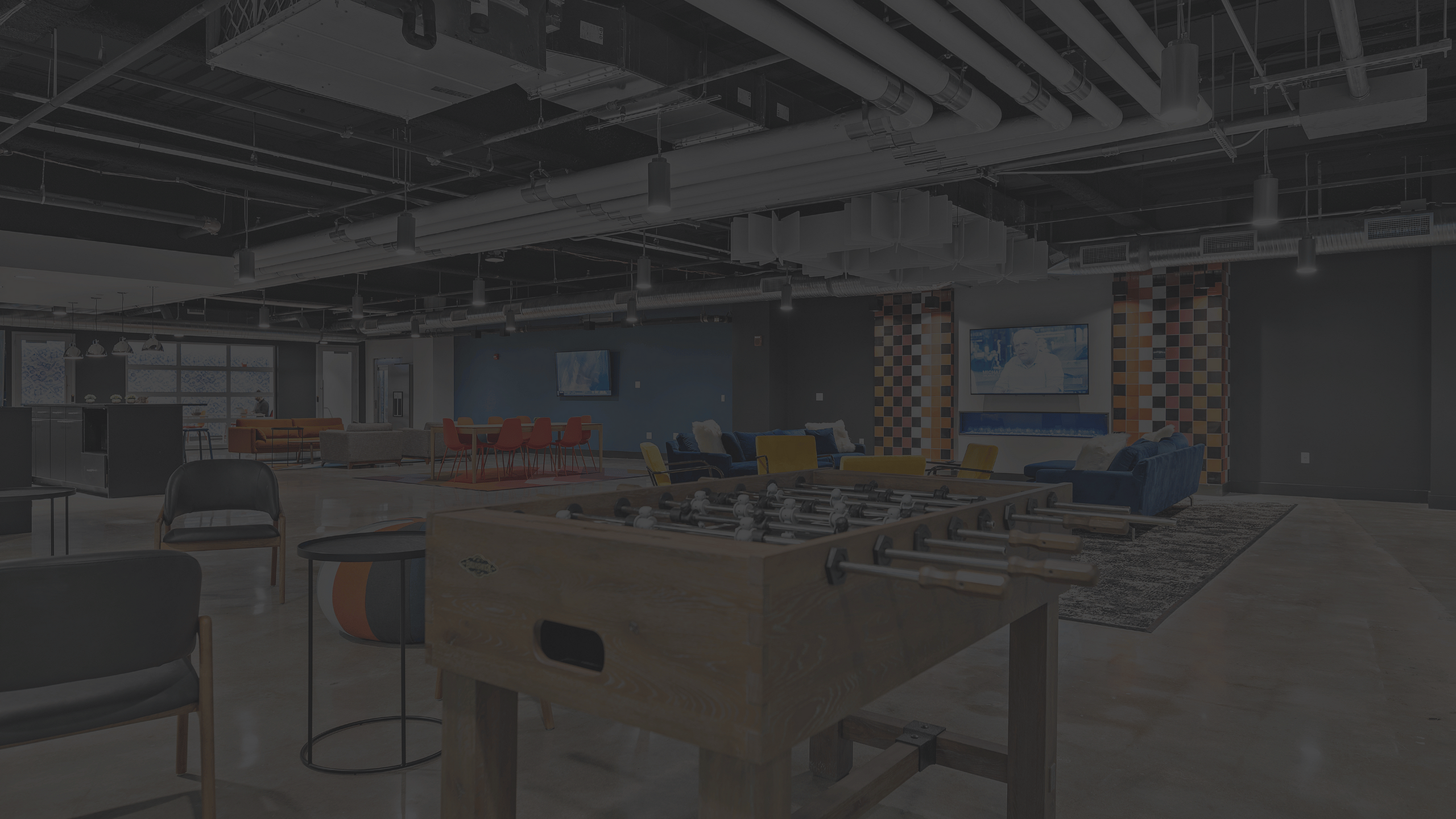 foosball table surrounded with comfy working spaces